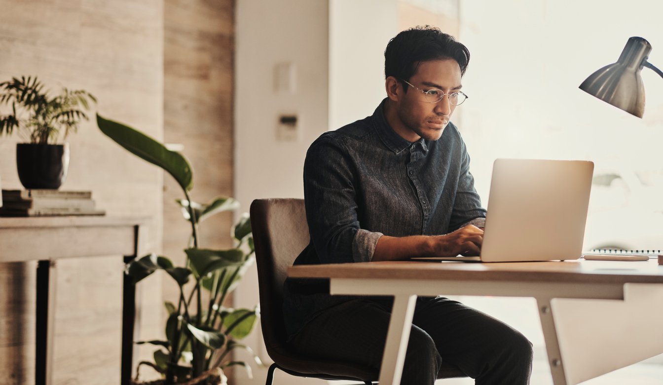 person sitting at desk working on laptop