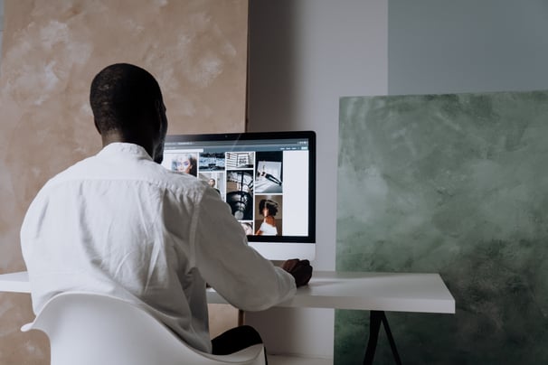 man looking at photos on desktop mac