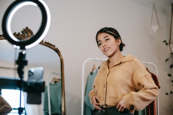 woman taking video in front of mobile phone and ring light