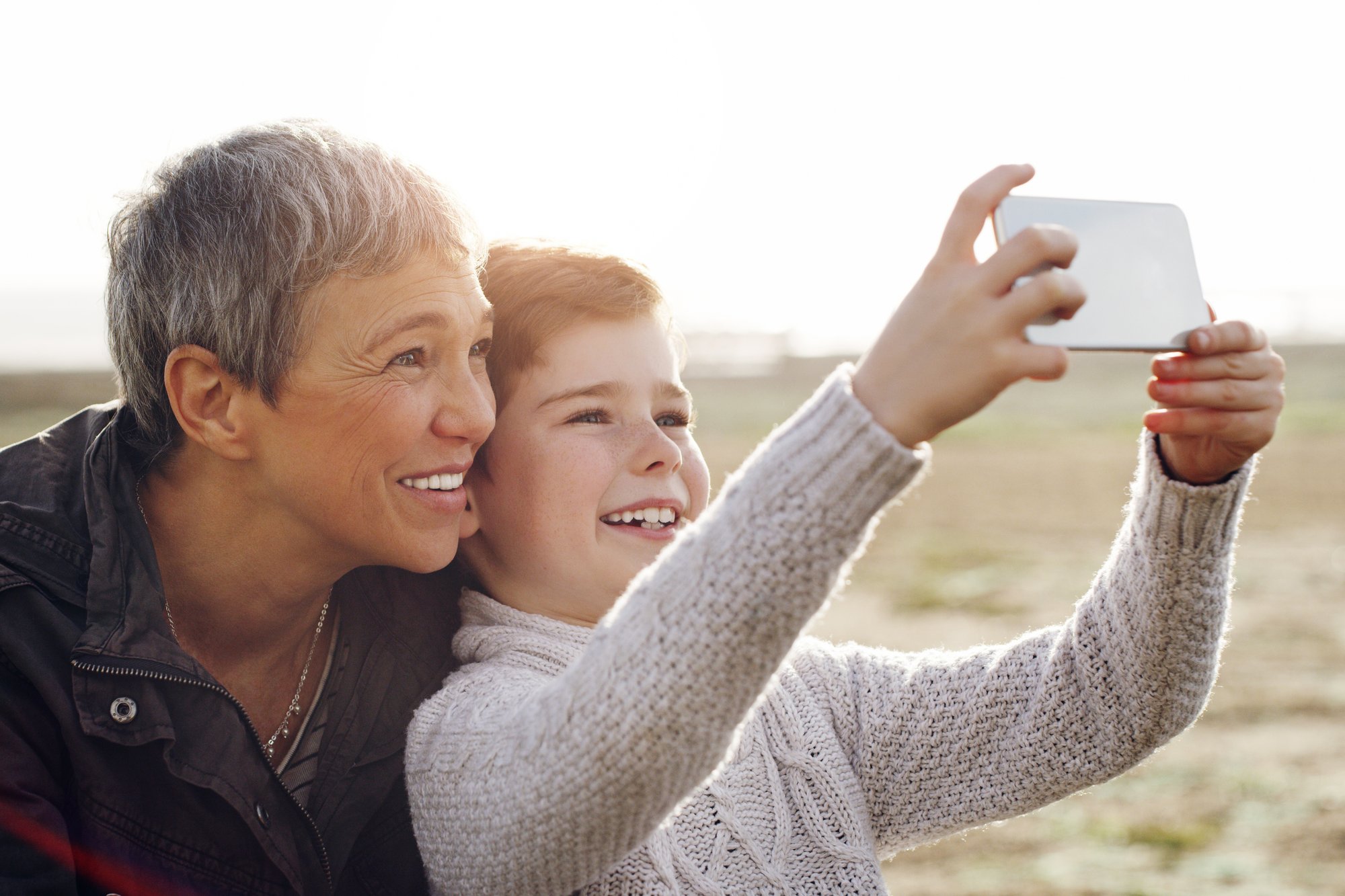 pose-camera-grandma-shot-adorable-little-boy-taking-selfie-with-his-grandmother-outdoors