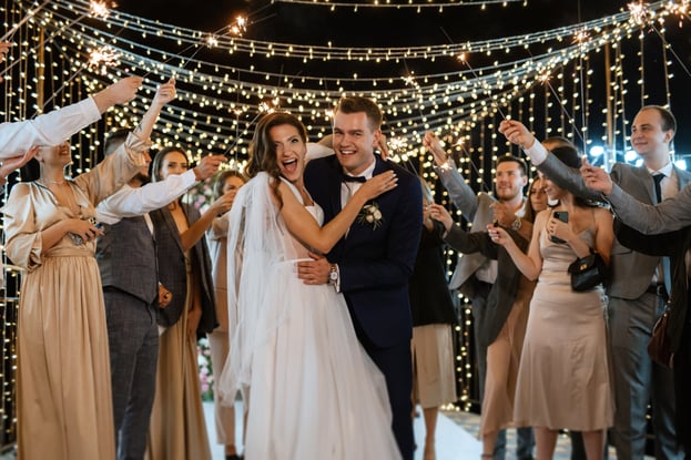 sparklers-wedding-newlyweds-hands-joyful-guests