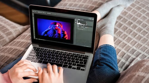young-content-creator-girl-is-her-laptop-sitting-sofa-working-with-photos-from-home